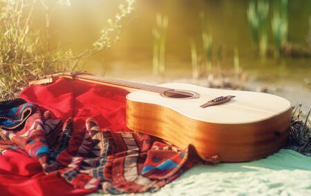 guitar on a blanket on the ground in natureの写真素材