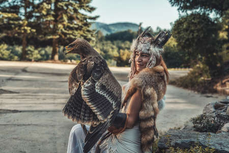 beautiful shamanic woman with eagle in the nature.の写真素材