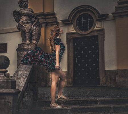 beautiful fashion model near an angel statue.