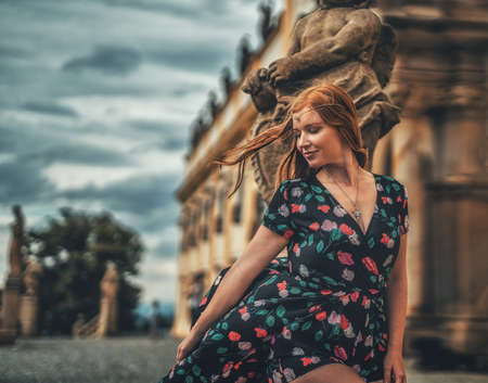 beautiful fashion model near an angel statue.の写真素材