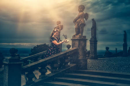 beautiful fashion model near an angel statue.の写真素材