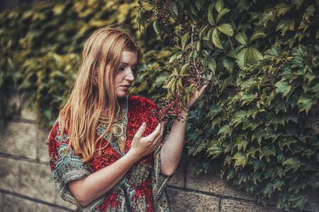woman in ornamental dress near the vineyard.の写真素材