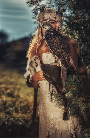 beautiful shamanic woman with eagle in the nature.の写真素材