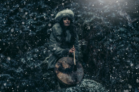 beautiful shamanic girl playing on shaman frame drum in the nature.の写真素材
