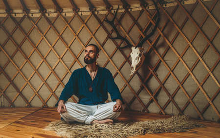 beautiful shamanic man with deer skull in yurt.の写真素材