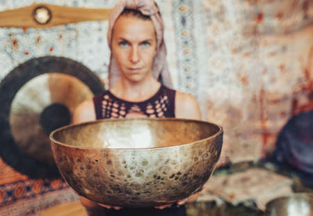 Spiritual girl immersed in meditative sounds of tibetian bowl.の写真素材