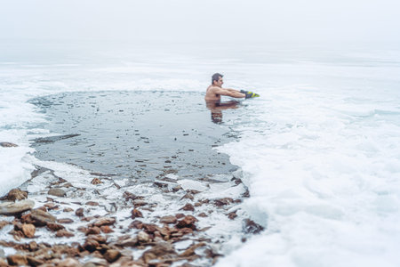 Winter swimming. Man in an ice-hole.