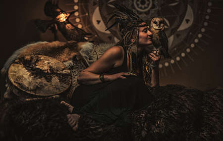 beautiful shamanic woman with owl in the interiors.の写真素材