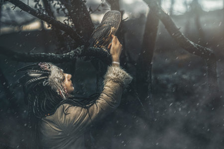 beautiful shamanic woman with owl in the nature.