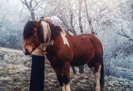Shaman woman in winter landscape with her horse.の写真素材