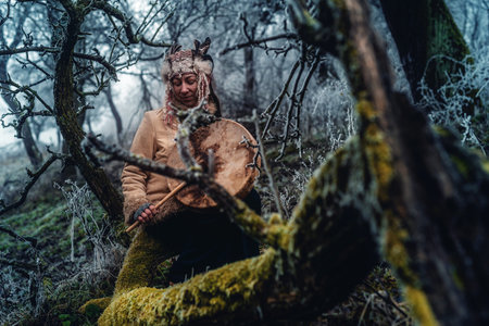 beautiful shamanic girl playing on shaman frame drum in the nature.の写真素材