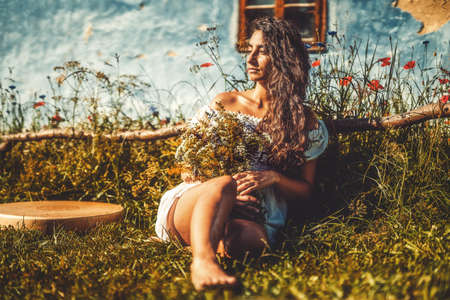 beautiful shamanic girl playing on shaman frame drum in the nature.の写真素材