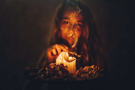 incense in a woman hand, incense smoke on a black background.の写真素材