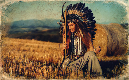 beautiful shamanic girl in the nature with a bow.の写真素材