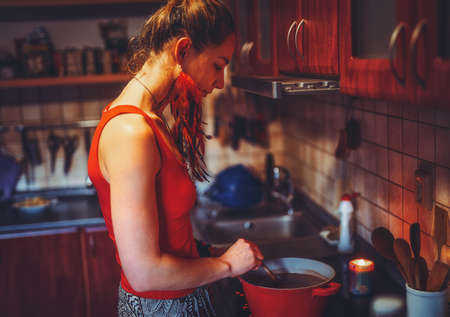 beautiful woman boiling cocoa in the kitchen.の写真素材