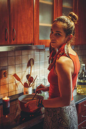 beautiful woman boiling cocoa in the kitchen.の写真素材
