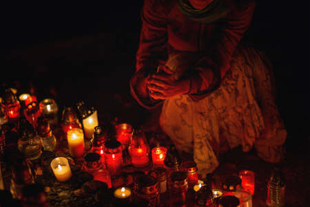 prayer woman. Candles in the cemetery. 1st November. Feast of All Saints. Hallowmas. All Souls Day.の写真素材