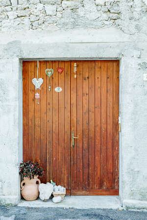 brown wooden door with flower and flowers.の写真素材