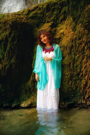 beautiful woman in beautiful dresses near the waterfall.
