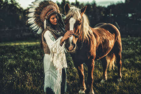 Shaman woman in landscape with her horse.の写真素材