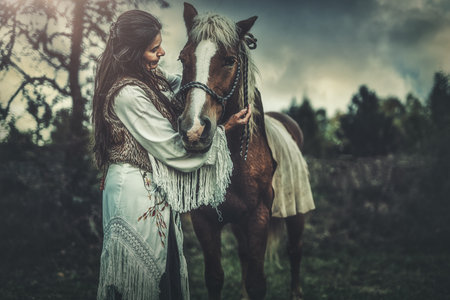 Shaman woman in landscape with her horse.の写真素材