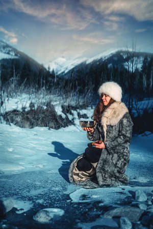 Beautiful shamanic girl playing on tibetian bowl in the nature.の写真素材