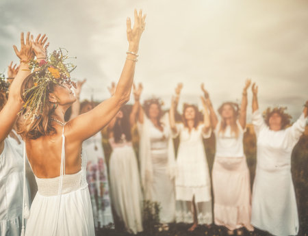 Women in flower wreath on sunny meadow, Floral crown, symbol of summer solstice.の写真素材