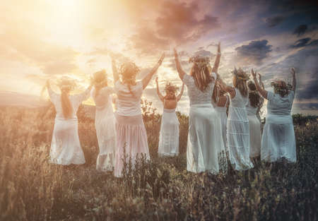 Women in flower wreath on sunny meadow, Floral crown, symbol of summer solstice.の写真素材