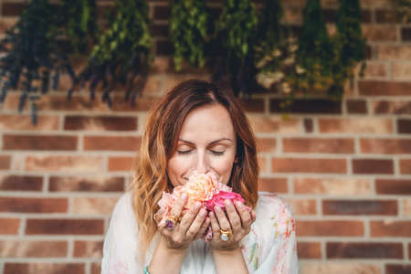 young beautiful woman with rose flowers in her hands.の写真素材