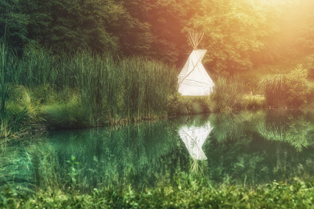 white teepee indian tent standing in beautiful landscape.