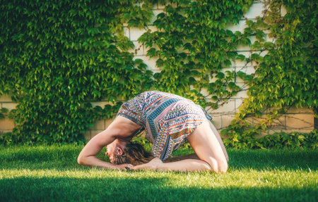 Beautiful woman practicing yoga in the garden.の写真素材