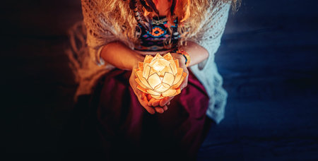 beautiful meditating woman with lotus candle in her hand.