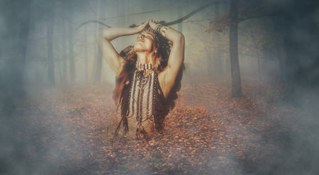 beautiful shamanic girl in the nature with a bow. Indian woman.の写真素材