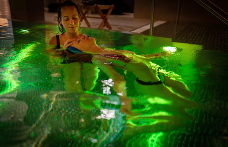 Therapeutic exercise in the pool. Woman receiving an aquatic therapy in the pool. Water relaxation...