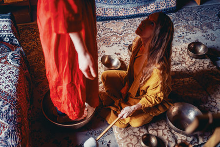 beautiful woman playng on tibetan bowl. Woman on music therapy. ceremonial space.の写真素材