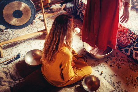 beautiful woman playng on tibetan bowl. Woman on music therapy. ceremonial space.