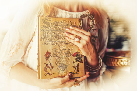 Woman holds ornamental book and Egyptian anch.