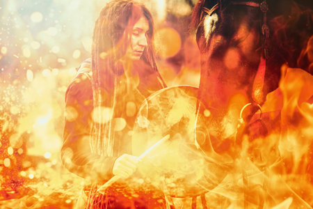 Shaman woman with her horse and shamanic frame drum. Fire backgroundの写真素材