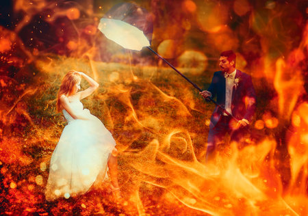 bride posing for her groom with photo equipment in landscape. Fire effect.