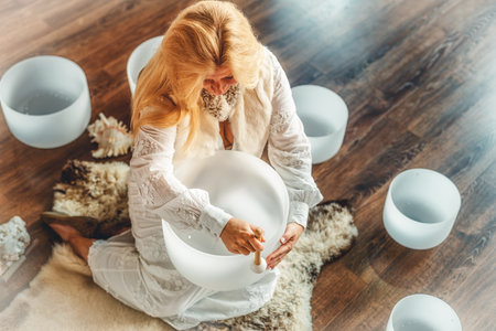 Woman playing on a crystal bowl. Ceremony space.の写真素材