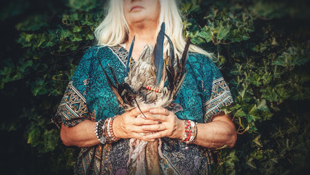 Shaman woman with feathers in hand.の写真素材