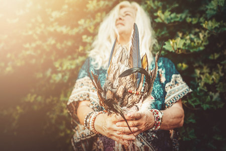 Shaman woman with feathers in hand.の写真素材