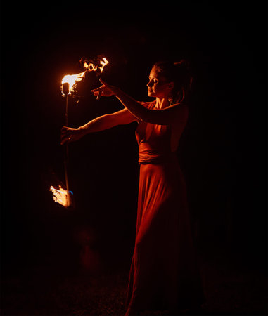 An enchanting fire dancer beautifully showcases her talent with mesmerizing flames during a...