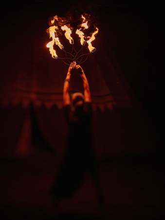 An enchanting fire dancer beautifully showcases her talent with mesmerizing flames during a performance.の写真素材