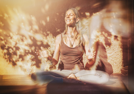 Beautiful woman practicing yoga on a terrace.の写真素材