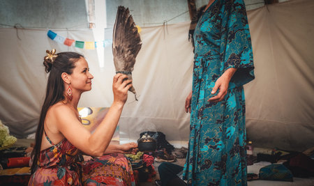 woman purifying the space with a ceremonial feather fan.