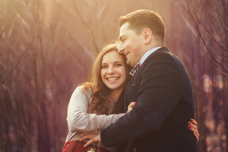 happy couple smiling in the park at sunsetの写真素材