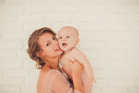 Mother holding sweet naked baby boyの写真素材