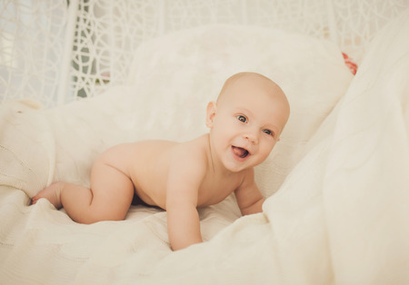 Adorable baby boy in bedroom. Newborn child relaxing in bed. Nursery for young children. Textile and bedding for kids.の写真素材