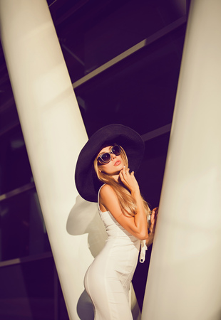 Beautiful sexy blonde woman in white dress posing in cityの写真素材